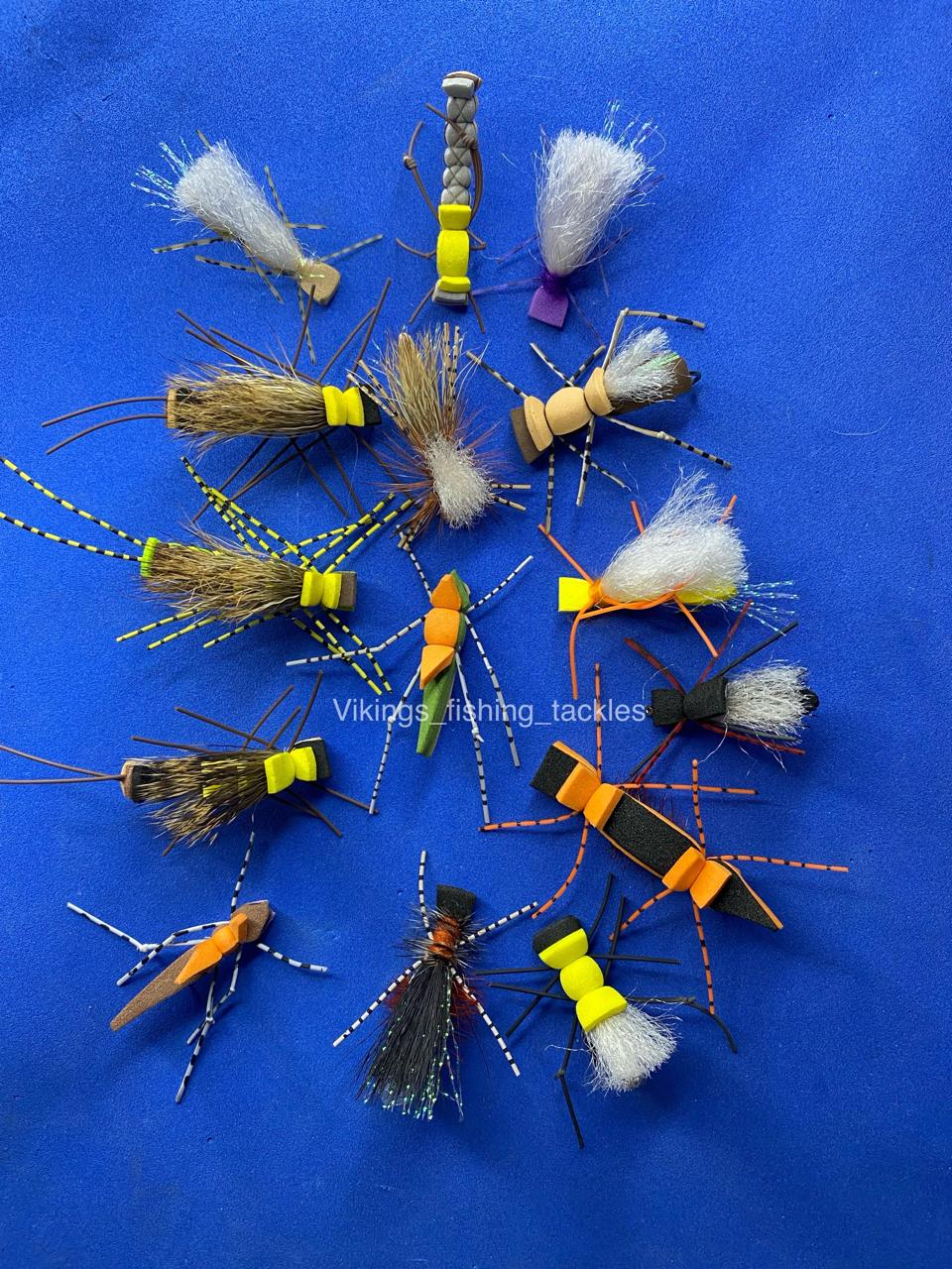 Flat-lay of hand-tied foam hopper and foam ant flies including Morris hopper and Fat Albert patterns for trout and bass