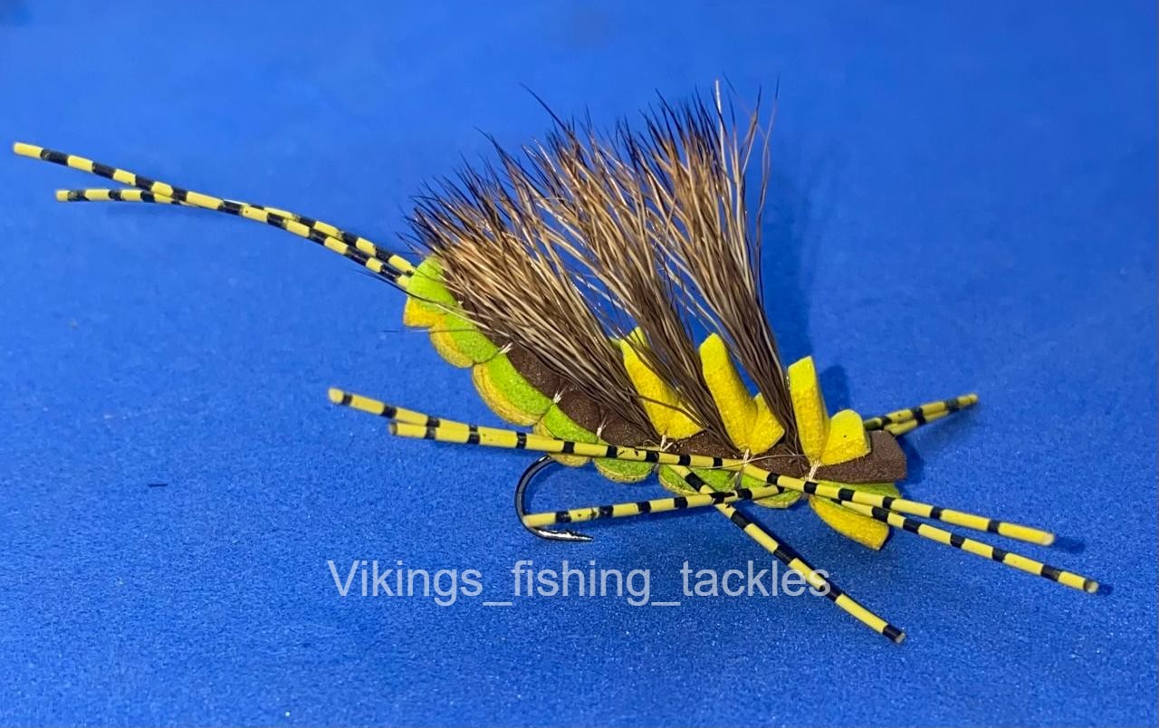 Close-up of a hand-tied foam hopper fly with a layered chartreuse and brown foam body, deer hair wing and barred rubber legs